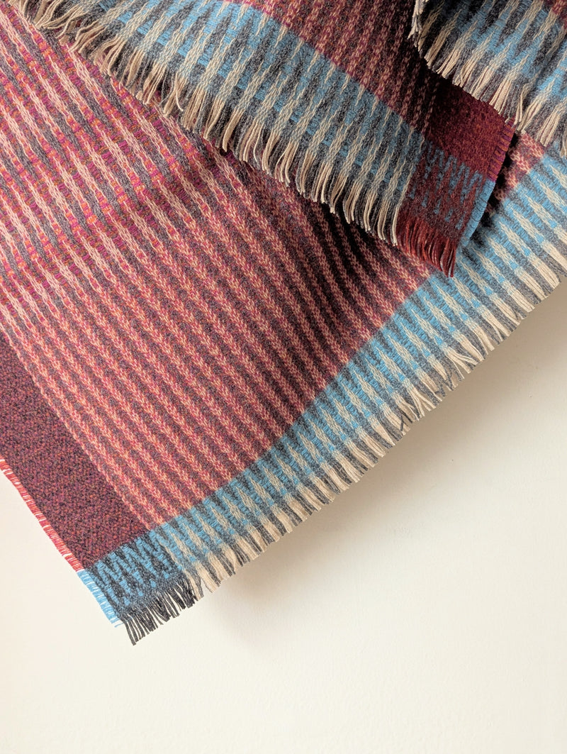 Plaid blanket with red and blue stripes on a white background