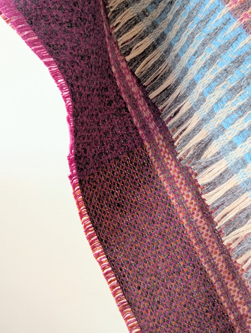 Close-up of a textured fabric with a patterned edge on a plain background