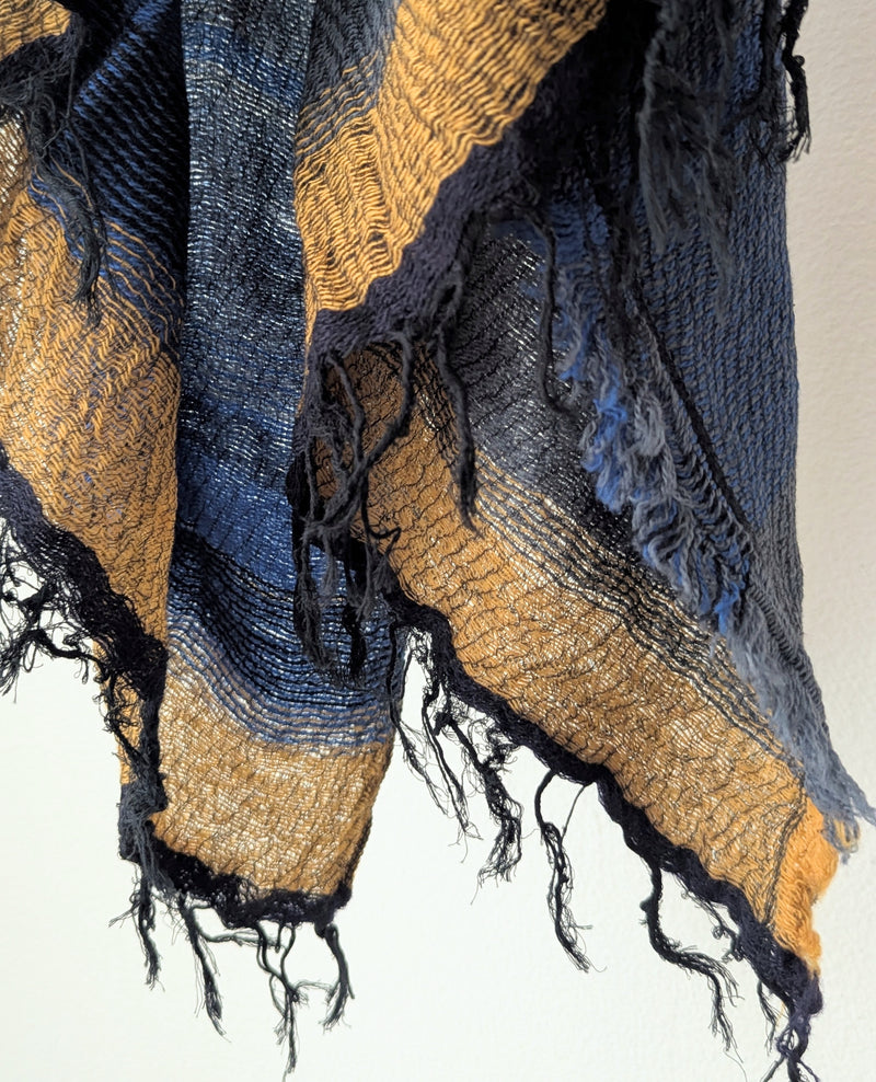 Woven scarf with blue and gold patterns on a white background