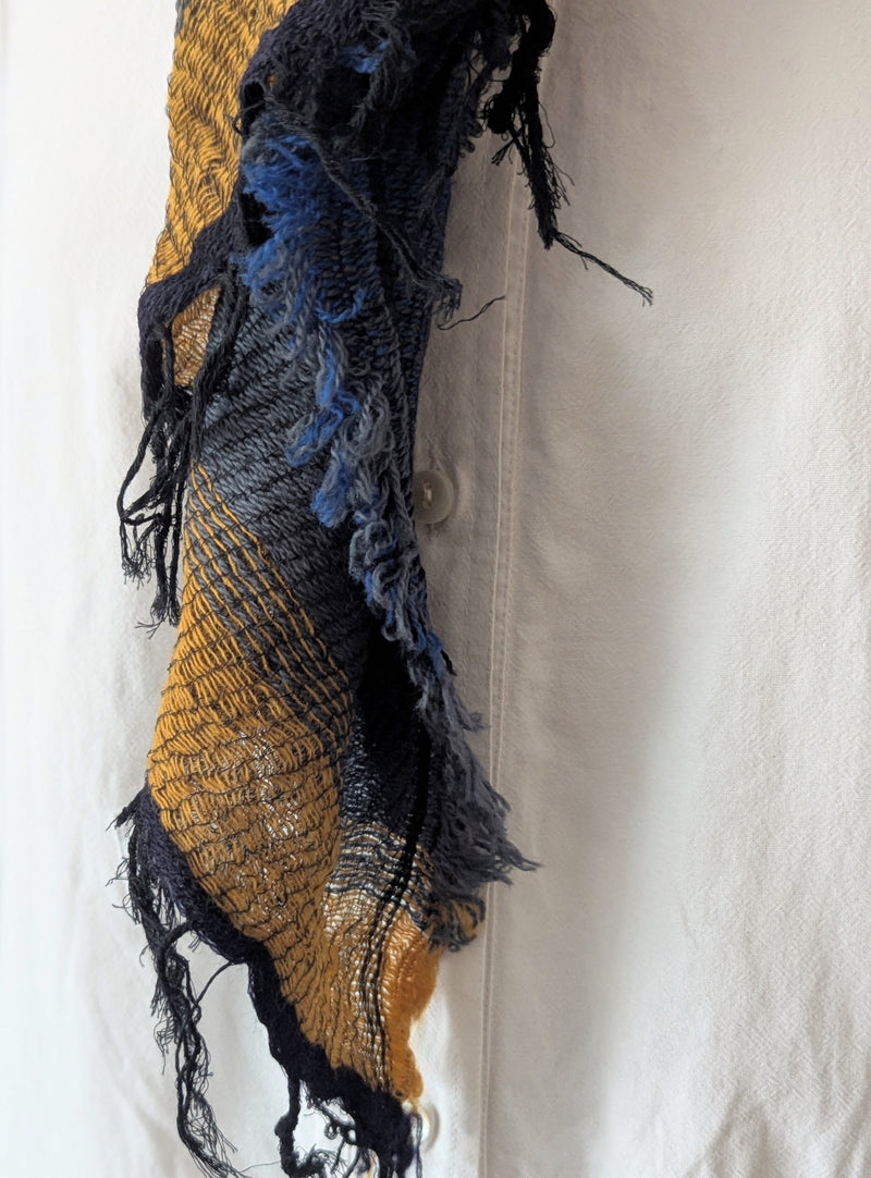 Textured scarf with blue and gold patterns on a white background