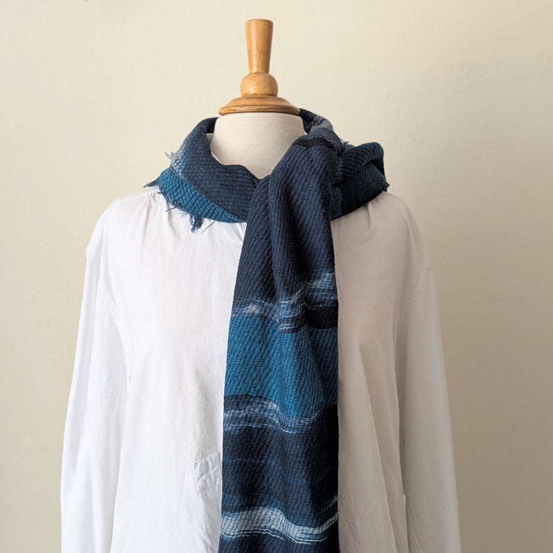Navy and teal scarf on a mannequin wearing a white shirt against a white background