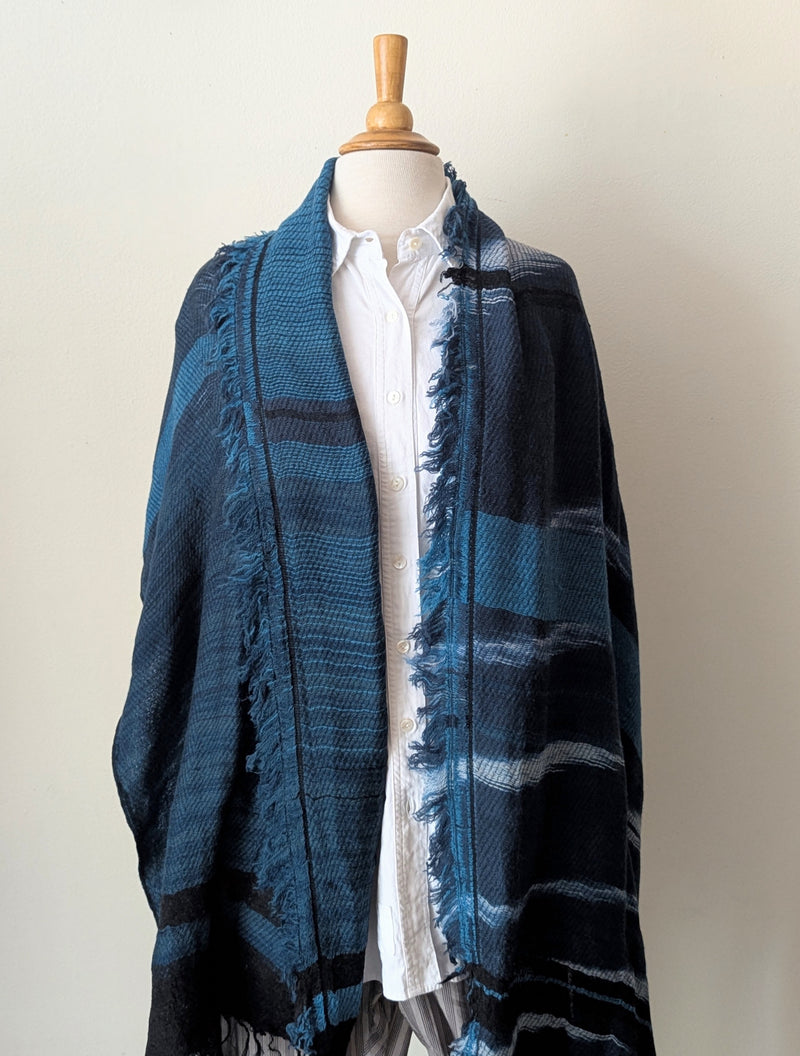 Navy and teal scarf on a mannequin wearing a white shirt against a white background