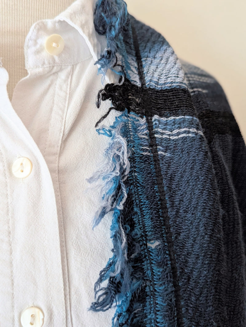 Navy and teal scarf on a mannequin wearing a white shirt against a white background