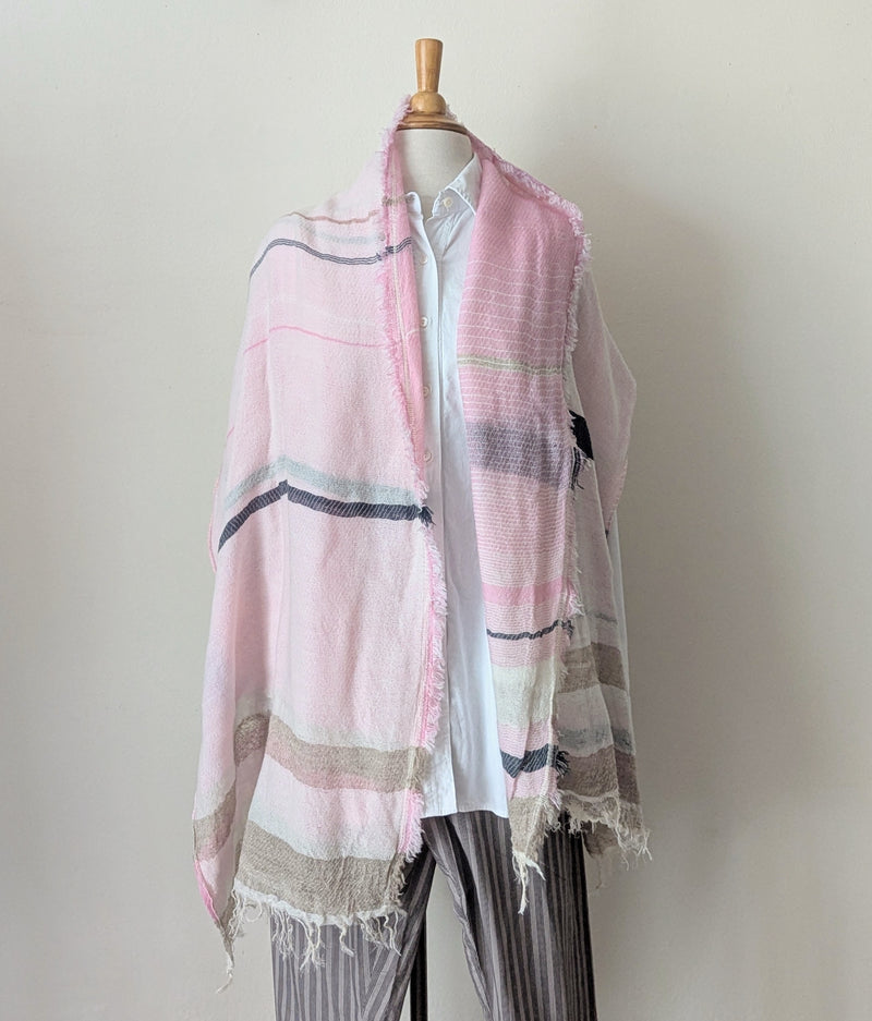 Mannequin wearing a white shirt with a pink and beige scarf draped over it against a plain background