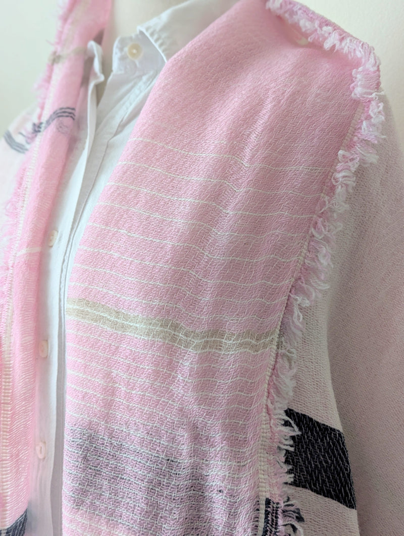 Mannequin wearing a white shirt with a pink and beige scarf draped over it against a plain background