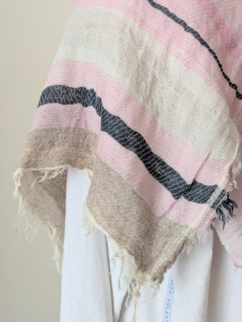 Mannequin wearing a white shirt with a pink and beige scarf draped over it against a plain background