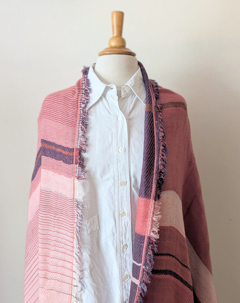 White shirt with a pink and blue striped scarf draped over it on a mannequin against a white background