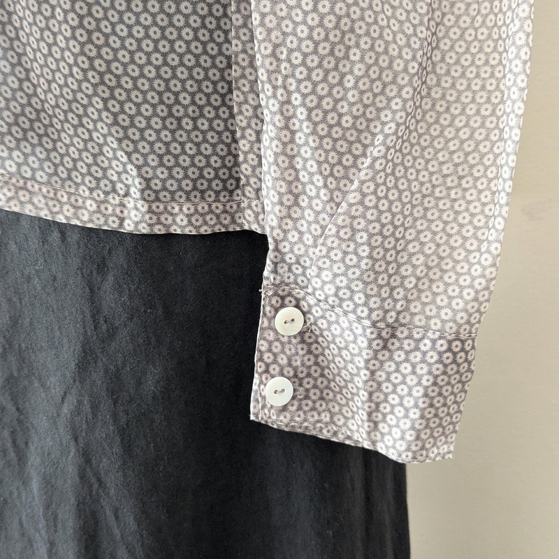 Close-up of a shirt with floral pattern and buttons on a beige background