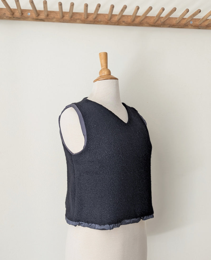 Black wool silk lined vest on a mannequin against a white background