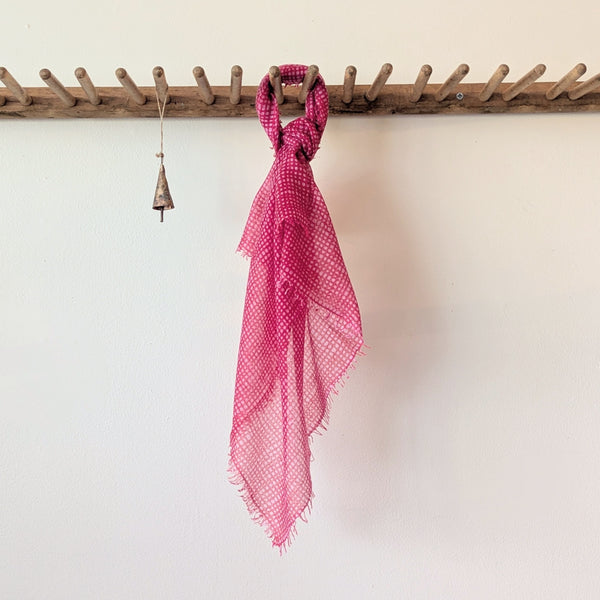 Pink checkered scarf on a mannequin against a white background