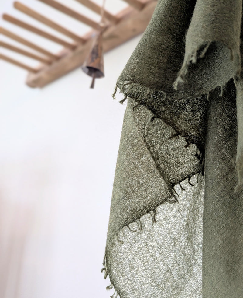 sheer cashmere scarf with frayed edges on a blurred background