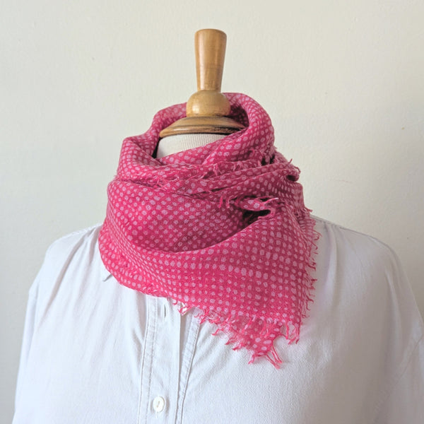 Pink checkered scarf on a mannequin against a white background