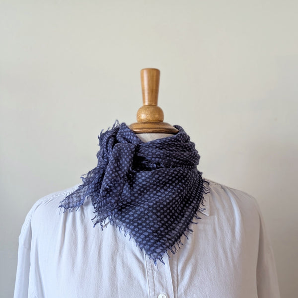 Navy blue patterned scarf on a mannequin with a white shirt against a plain background