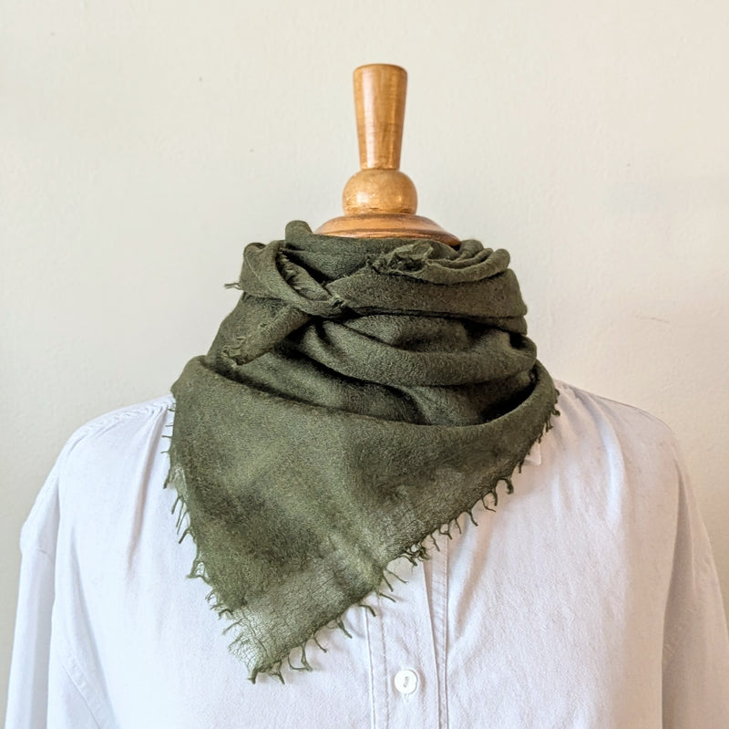 Green cashmere neckerchief scarf on a mannequin with a white background