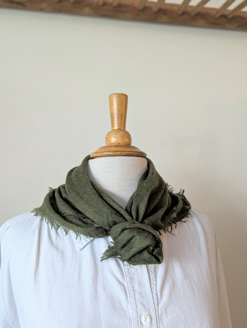 Green cashmere neckerchief scarf on a mannequin with a white background
