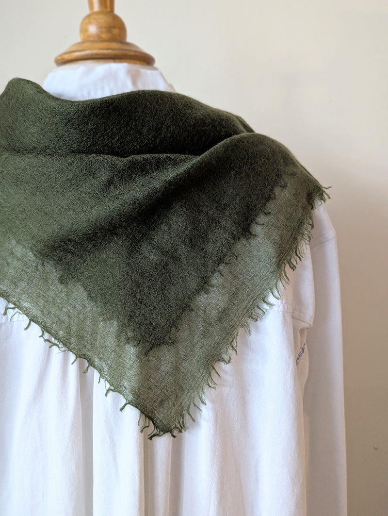 Green cashmere neckerchief scarf on a mannequin with a white background