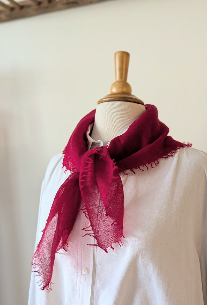 Mannequin wearing a white shirt with a red scarf against a plain background