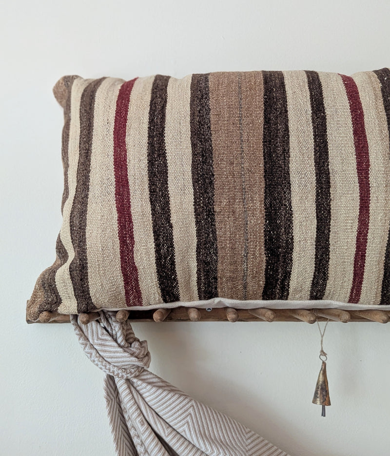 Striped pillow on wooden rack on a white background