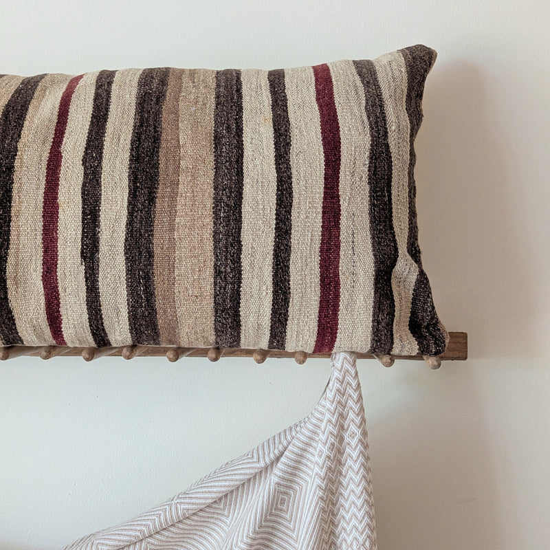 Striped pillow on wooden rack on a white background