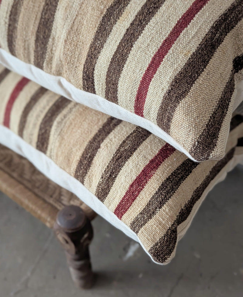 Close-up of a striped cushion on a wooden chair with a blurred background