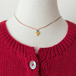 Necklace with orange cord with a blue bead and a gold heart pendant 