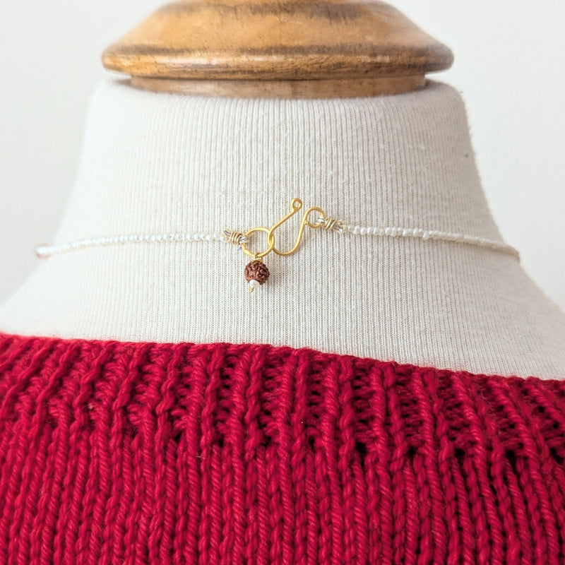 Delicate necklace with a gold clasp and brown seed bead on pearl beaded cord 