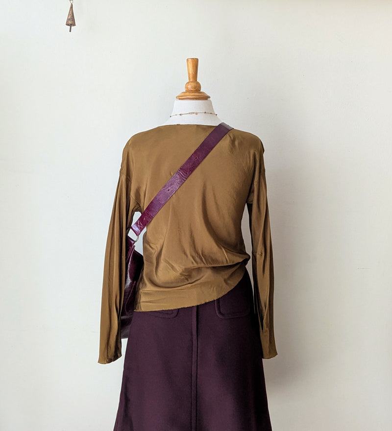 Tobacco brown draped silk blouse and maroon wool skirt from Susanne Bommer on a mannequin with a red Stitch & Tickle bag