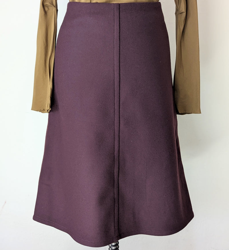 Mannequin wearing a brown long-sleeve top and bordeaux skirt from Susanne bommer 