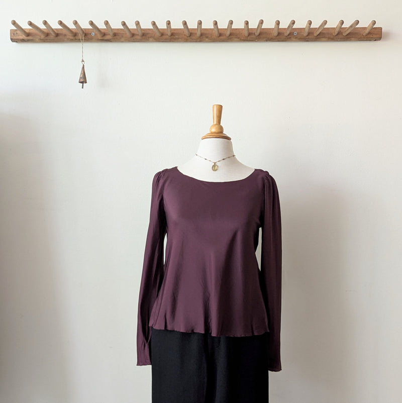 Susanne Bommer silk puff shoulder bordeaux long-sleeve top on a mannequin