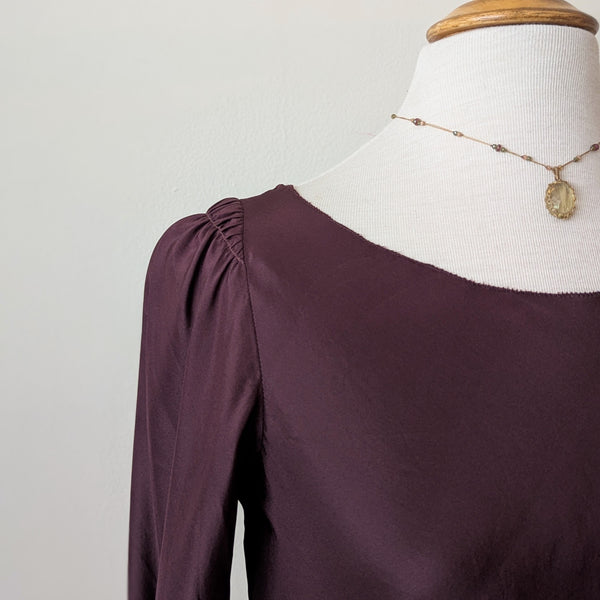 Susanne Bommer silk puff shoulder bordeaux long-sleeve top on a mannequin