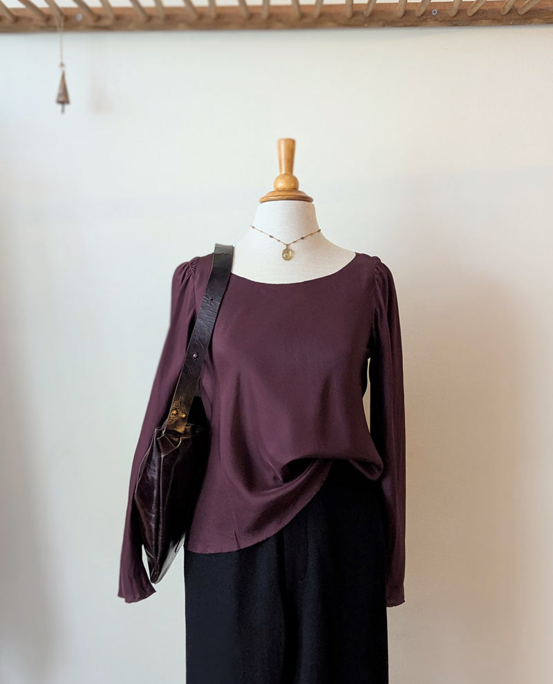 Mannequin wearing a burgundy top and black pants with a Stitch and Tickle Passy Bag in Espresso against a plain background