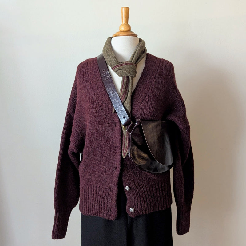 Mannequin wearing a maroon knitted cardigan with a Stitch & Tickle Passito leather bag in Espresso and scarf against a plain background