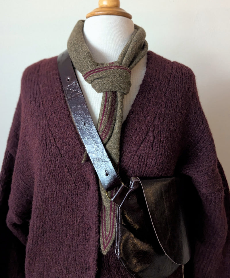 Mannequin wearing a dark purple sweater with a green scarf and a Stitch & Tickle Passito leather bag in Espresso over a white background
