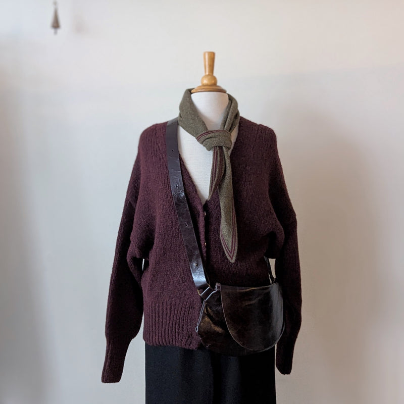 Mannequin wearing a maroon sweater, green scarf, and a Stitch & Tickle Passito leather bag in Espresso against a plain background
