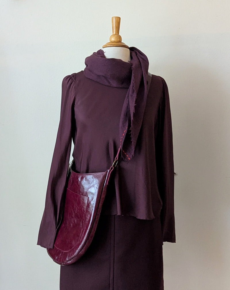 Mannequin wearing a dark purple outfit with a Stitch and Tickle Luna Bag in Wine  against a plain background