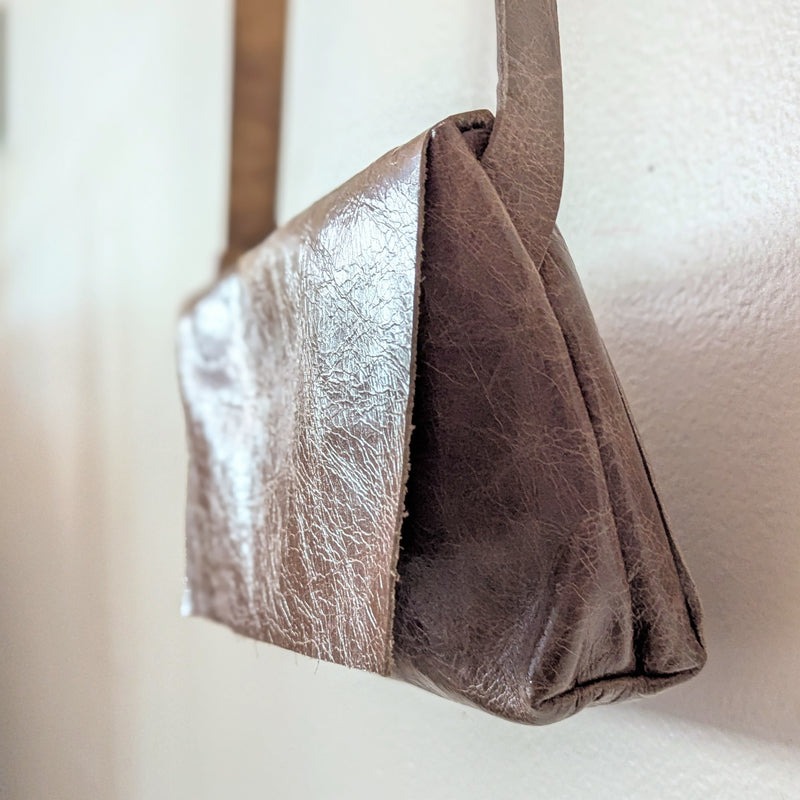 Stitch & Tickle mini messenger bag in Chai  with a textured surface on a light background