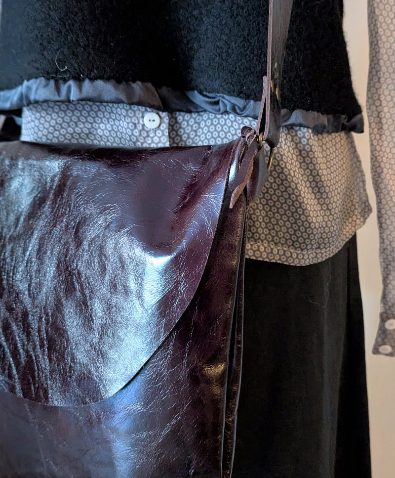 Close-up of a person wearing a dark outfit with aStitch and Tickle Passy Bag in Espresso 