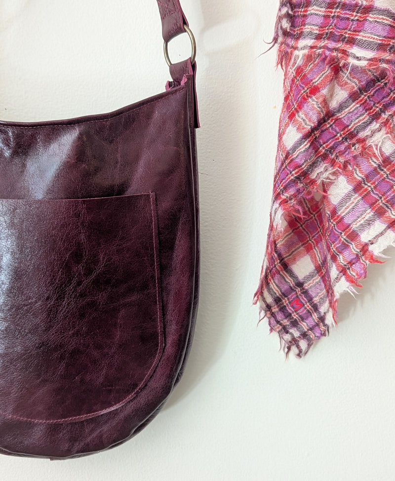 Stitch and Tickle Luna Bag in Wine  next to a plaid scarf on a white background