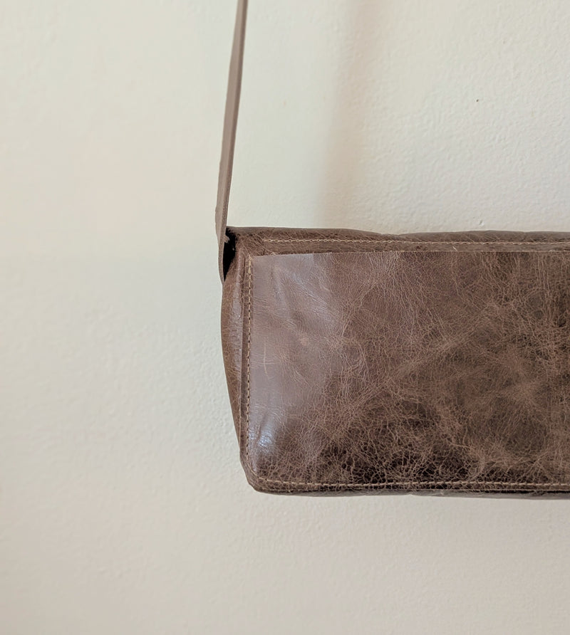 Stitch & Tickle mini messenger bag in Chai  on a light beige background