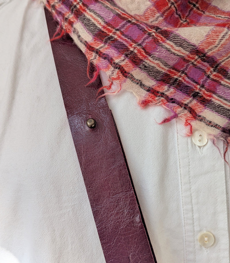 Plaid scarf draped over a white shirt showing the strap of a Stitch and Tickle Short Passy Bag in Wine 