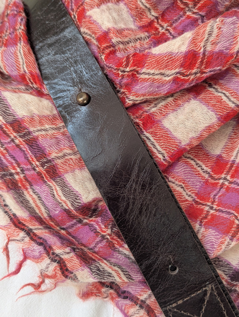 Close up of a Stitch & Tickle Passito leather bag strap in Espresso against a plaid moismont wool scarf