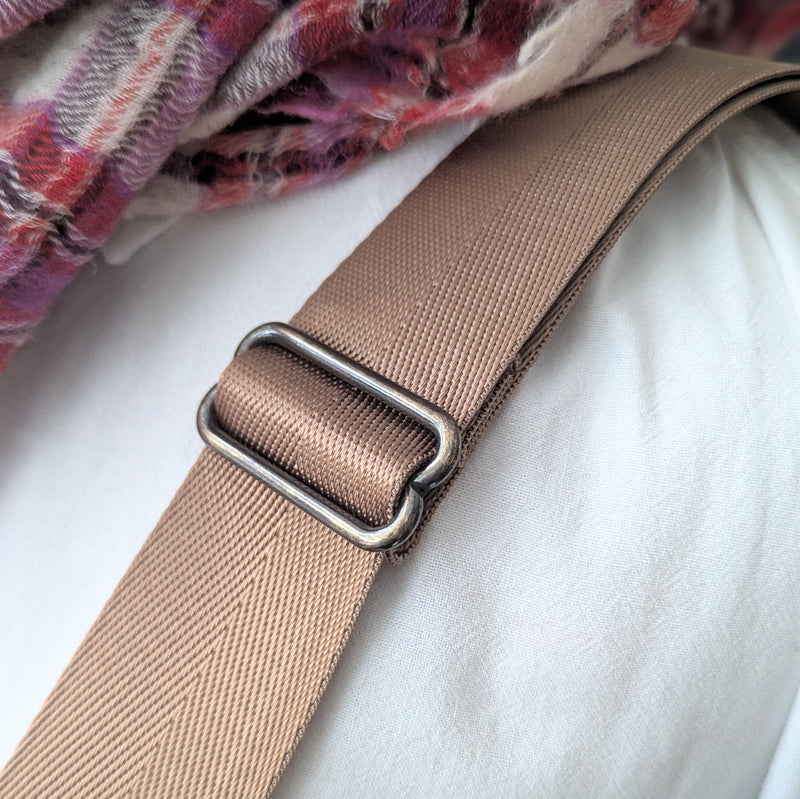 Beige strap with a metal buckle on a white background