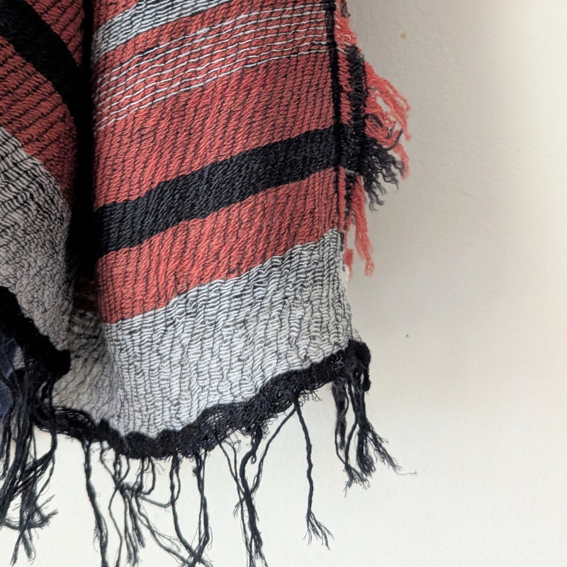 Striped scarf with red, black, and gray colors on a white background