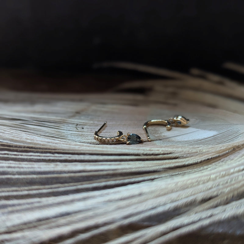 Gold earrings with sapphire gemstones and dimonds on a wooden surface