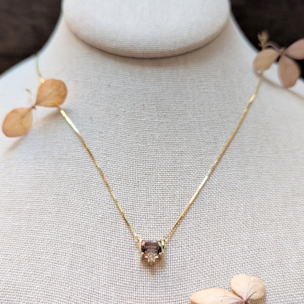 Gold necklace with a Watermelon Tourmaline gemstone and dimond pendant on a mannequin bust.