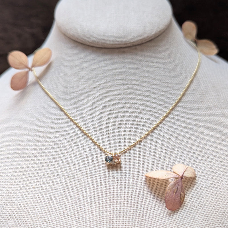 Gold necklace with two sapphires and a diamond on a mannequin