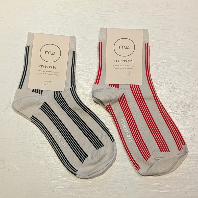 Two pairs of striped socks with 'memeri' branding on a light background