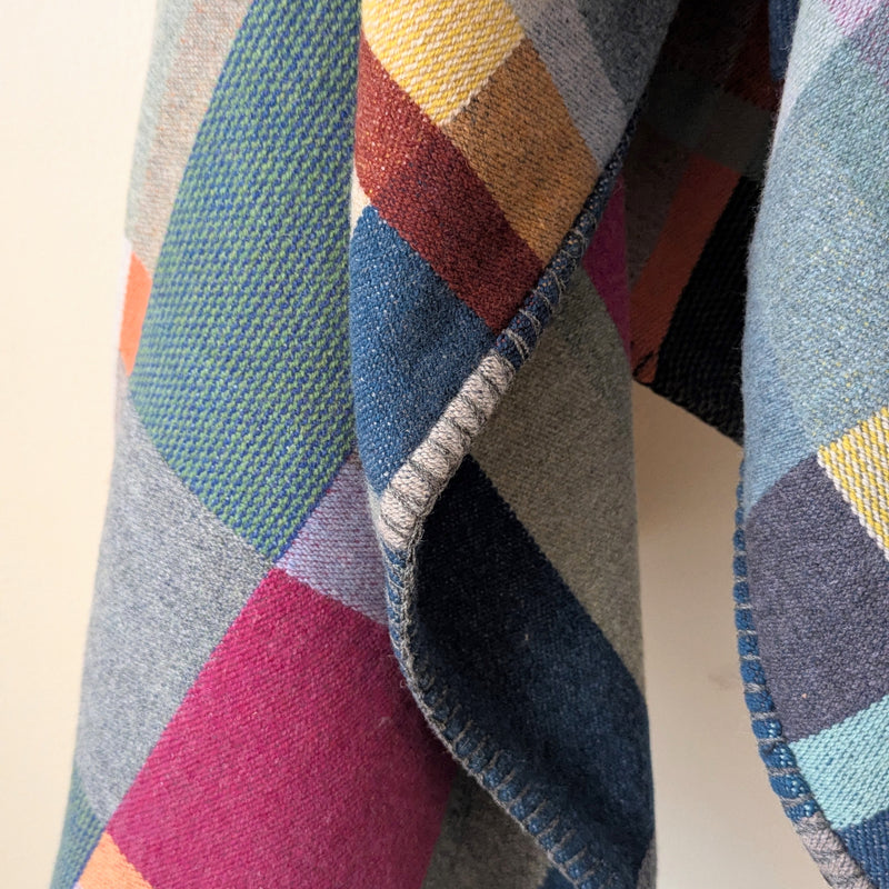 Close-up of a colorful woven fabric with geometric pattern on a neutral background