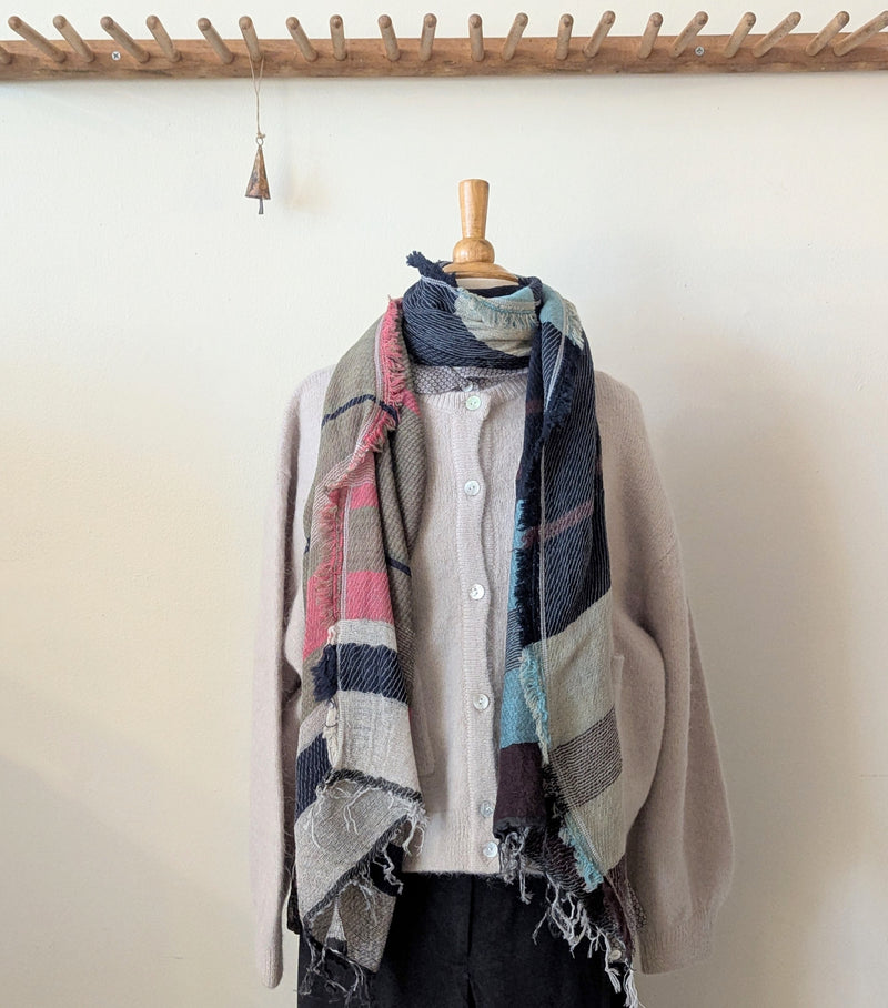 Plaid scarf draped over a mannequin against a white wall