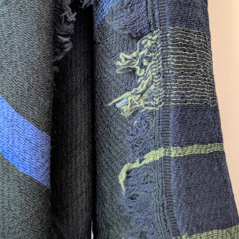 Textured fabric with blue and green patterns on a beige background